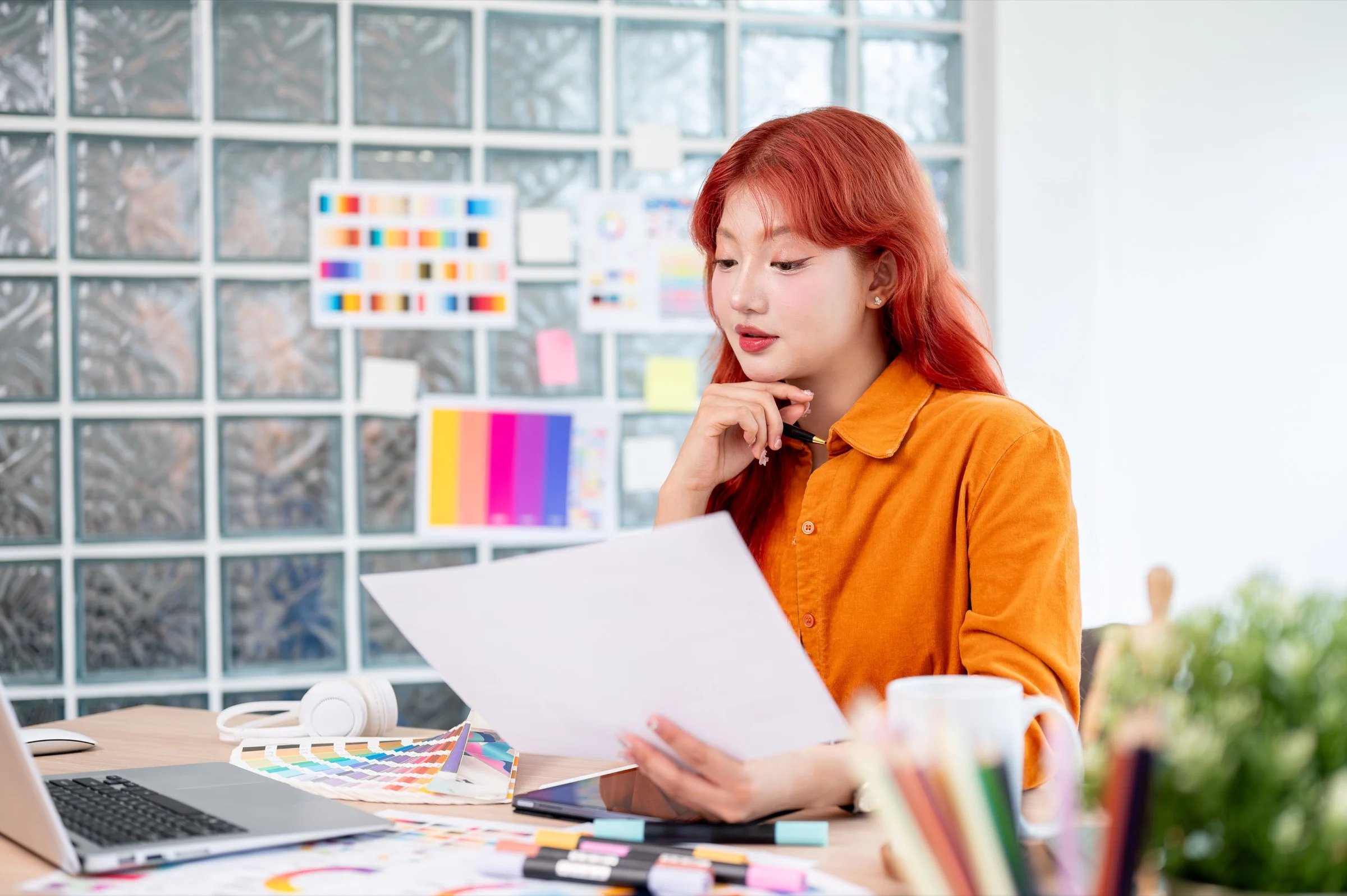 Focused Creative Asian Female Graphic Designer With Red Hair Is Working Her Desk Office